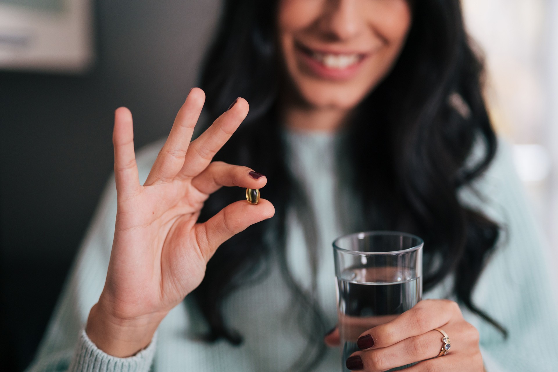 Lady holding pill and glass of water